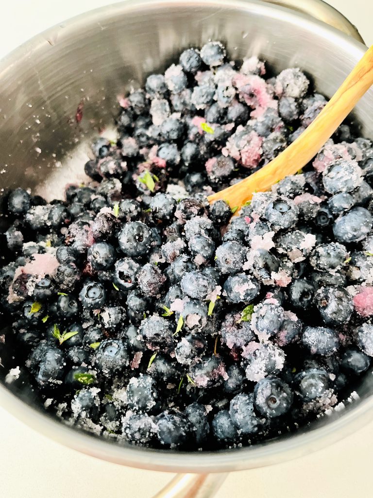 Add sugar to blueberries and mix them together