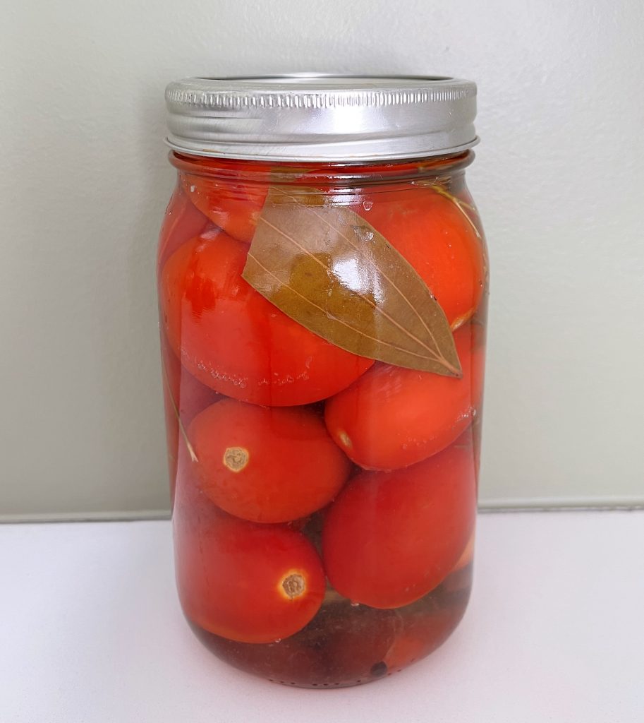 a jar of canned whole tomatoes made using open kettle canning (inversion canning)