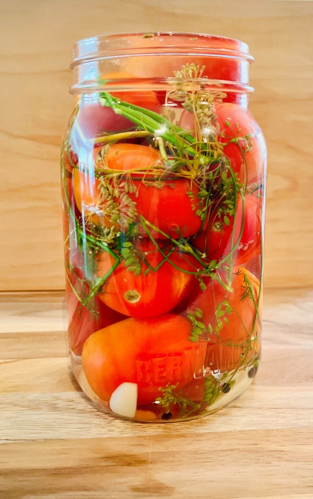 Pack tomatoes in jars and pour boiling water