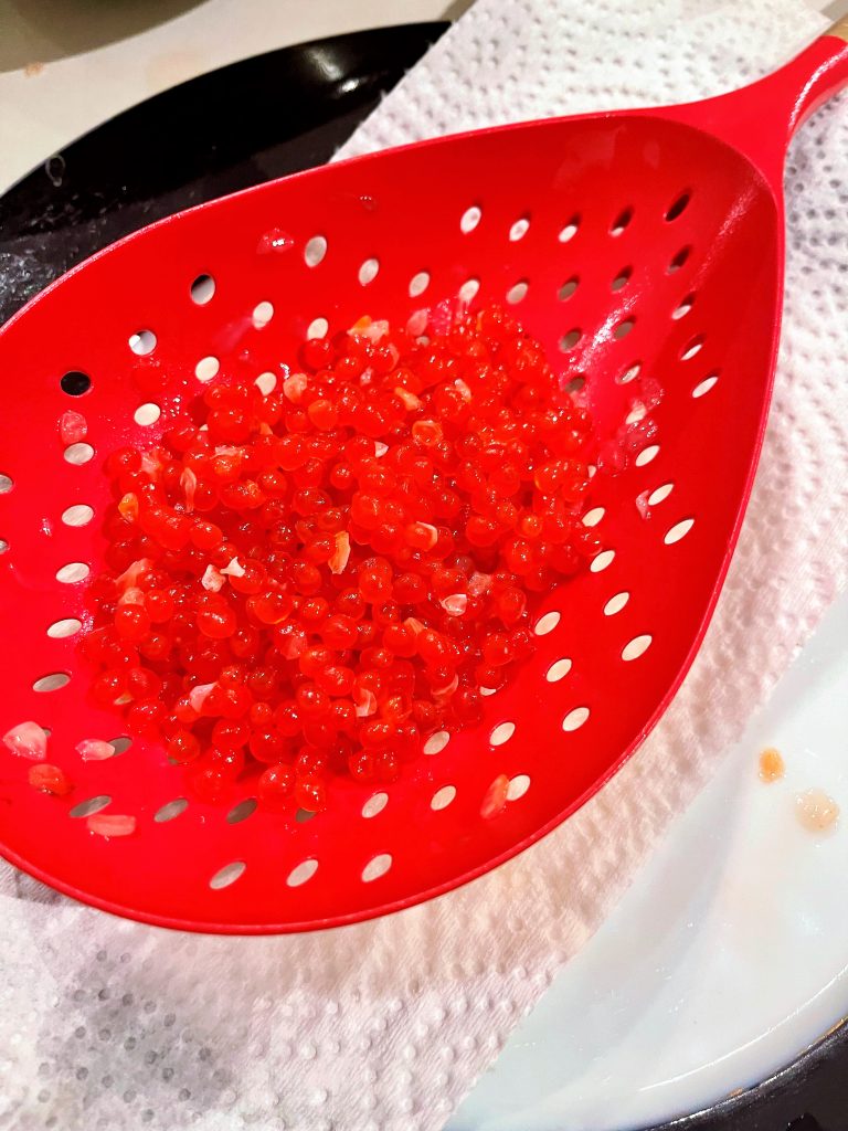 scoop out salmon eggs from brine