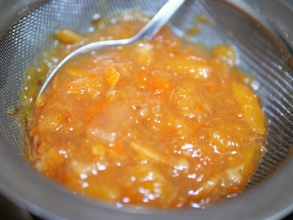 press cooked citrus and zest against the metal  strainer