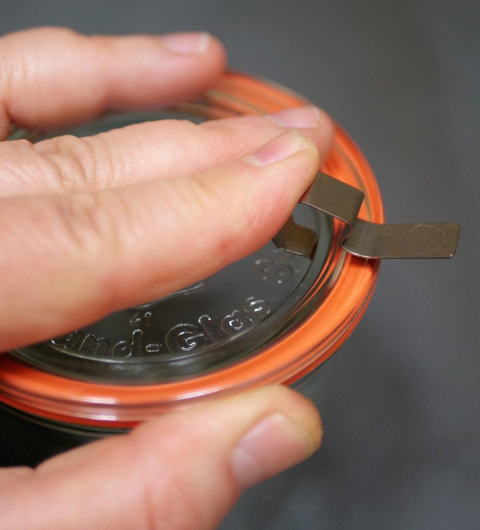 applying metal clamps to a glass lid