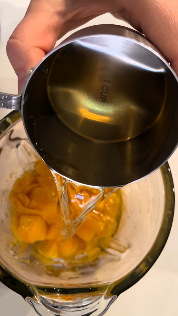To continue with a recipe, add diced mango to a blender and add vinegar