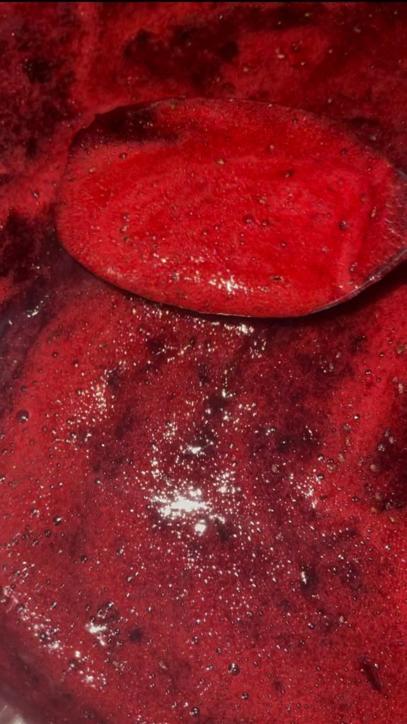 remove any foam from the surface of the cooking blackcurrant jam mixture