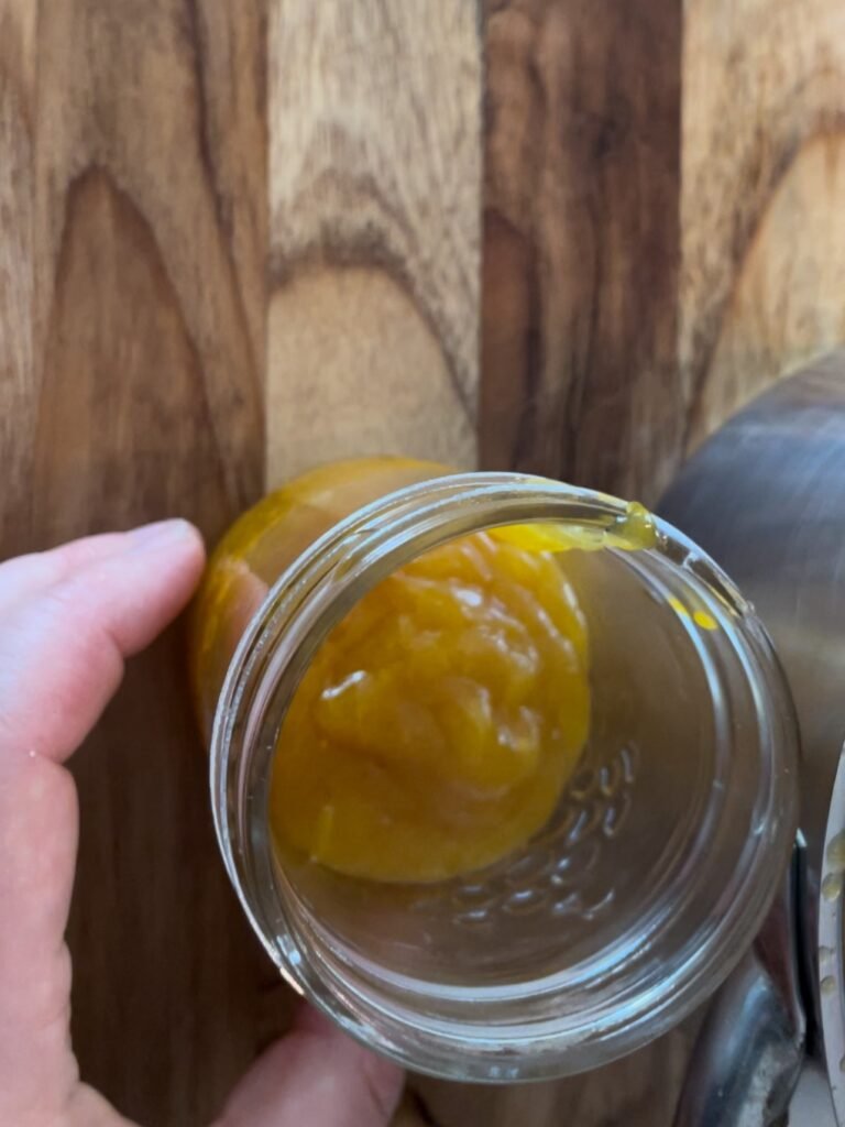 Pour mango guava jam into a canning jar and process