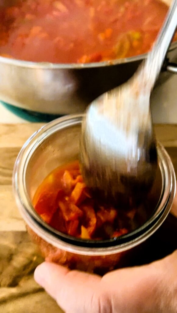 Pack cooked Hungarian lecho into canning jars