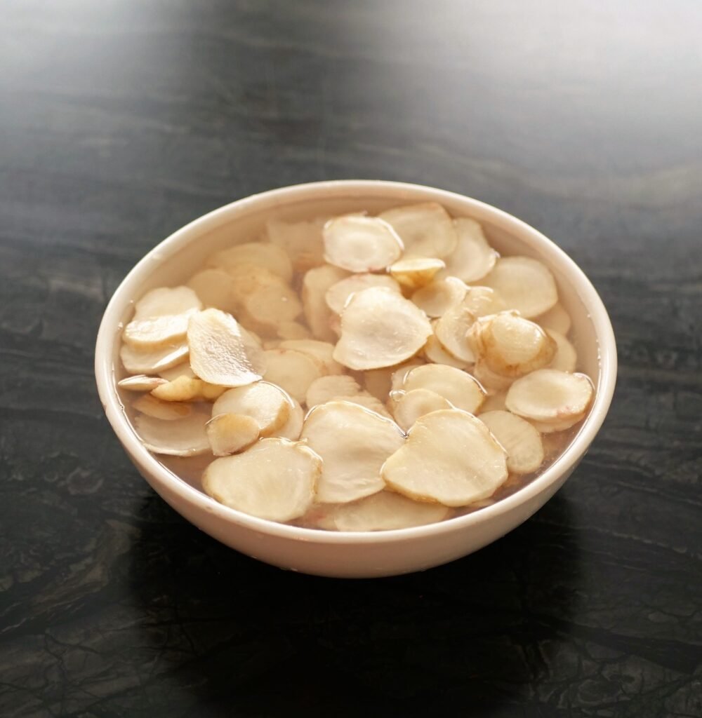 sliced sunchokes are getting soakes in a bowl of cold water with lemon juice