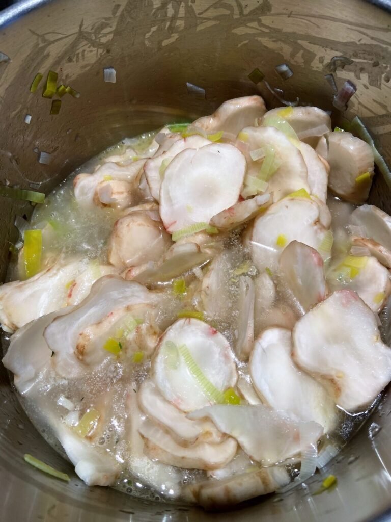 sunchokes are added to the pot and are getting covered with stock 