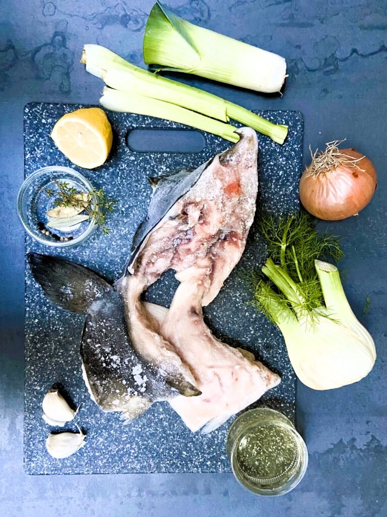 ingredients required to make fish stock sitting on a chopping board