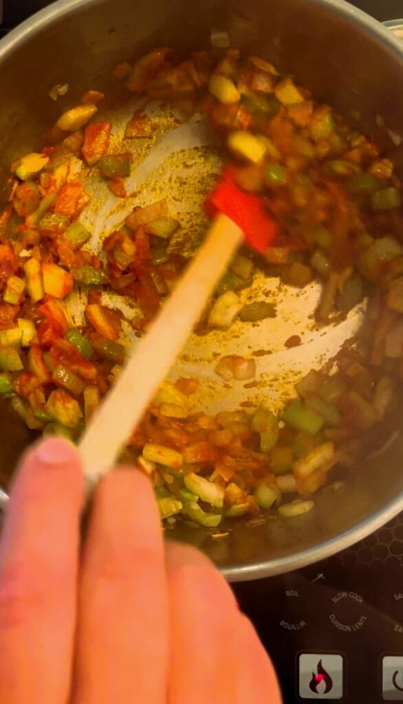 tomato paste is stirred into the cooking softened vegetables