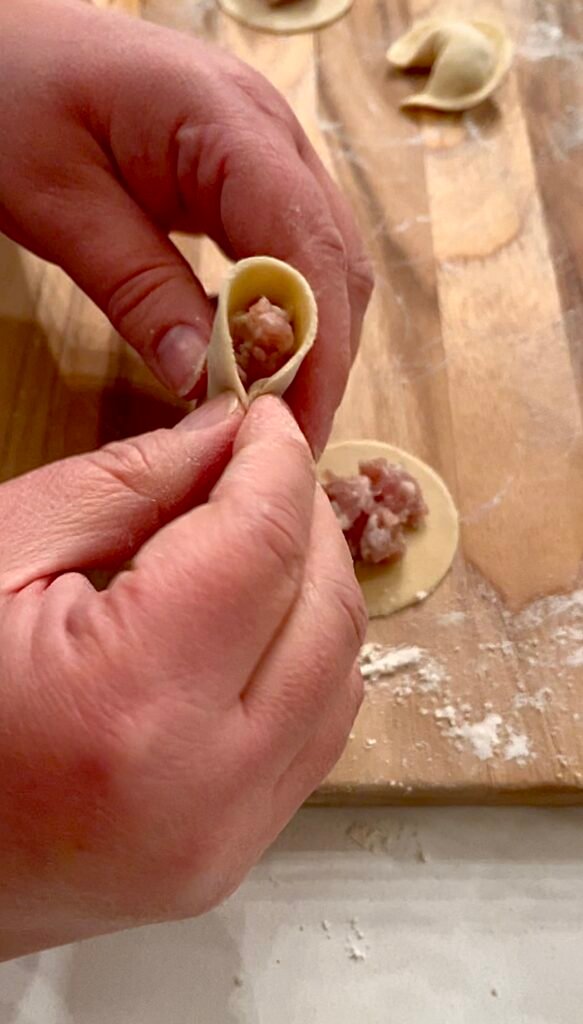 continue pinching dough to corner to completely enclose the filling