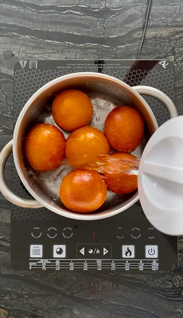 cover unpeeled oranges with water and bring to boil