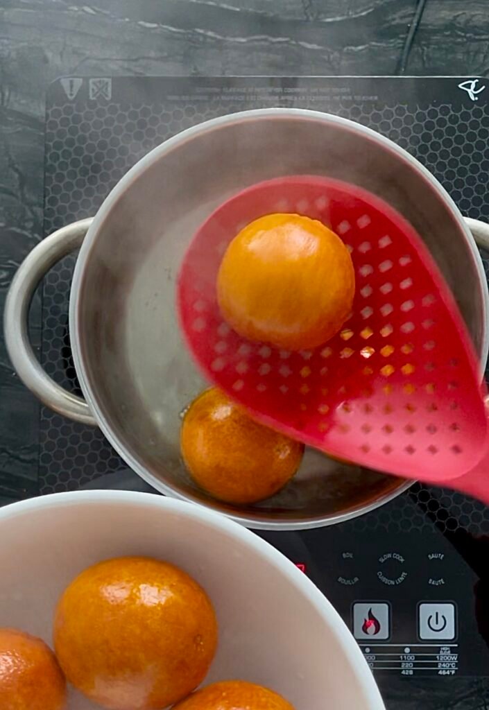 we use slotted spoon to remove cooked unpeeled oranges