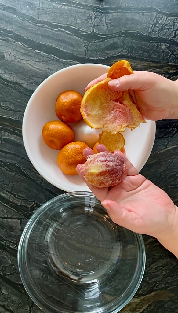 peel oranges and separate peel and peeled orange into separate bowls 