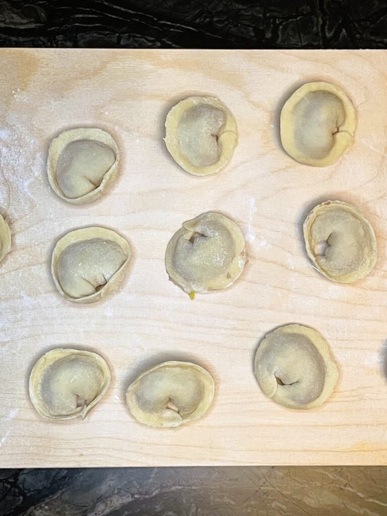 filled and shaped pelmeni equally spaced on the cutting board