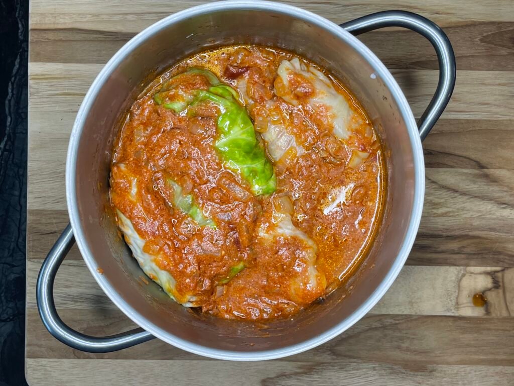 cabbage rolls covered in a sauce and liquid