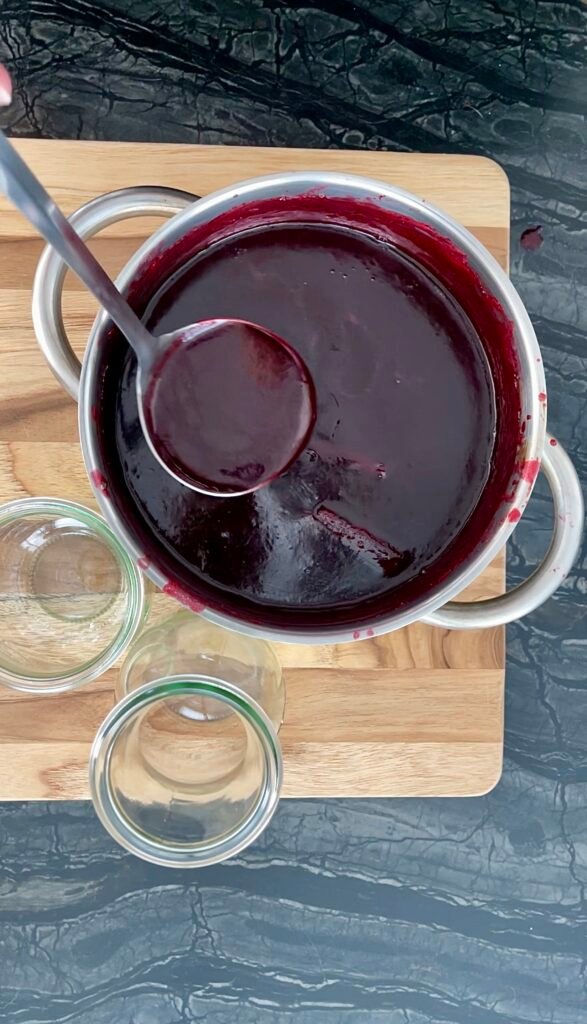 cooked spices raspberry syrup ready to be ladled into the jars