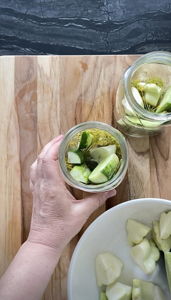 jar tightly packed with pattypan and cucumber spears