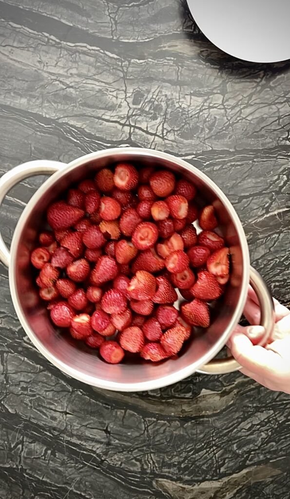 hulled strawberries placed in a heavy-bottomed pot