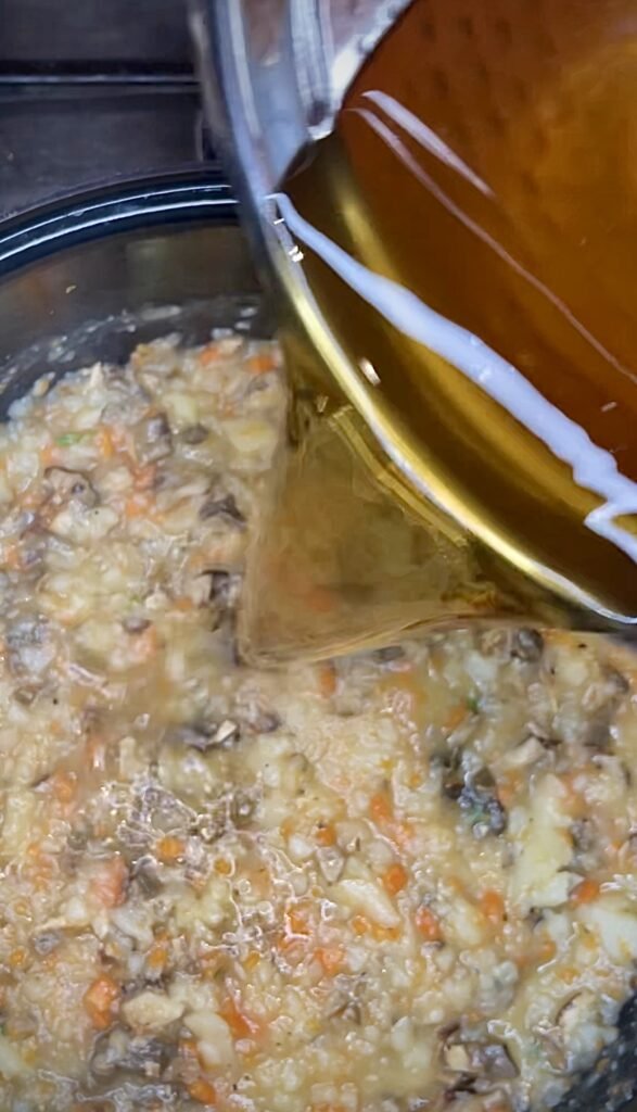 pour soaking porcini liquid over cooking vegetables and mushrooms