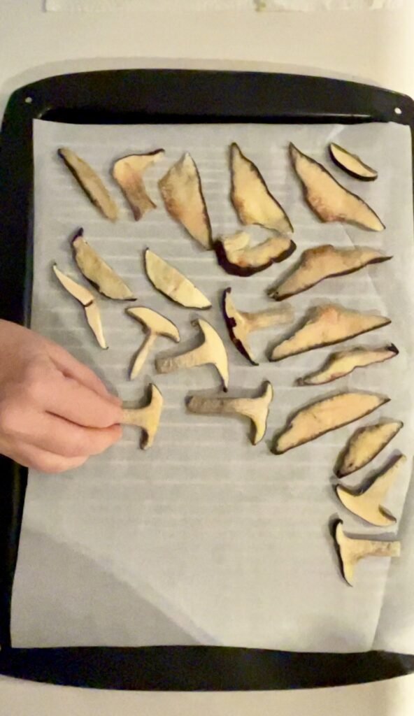 tray is lined with parchment before we start placing sliced mushrooms on