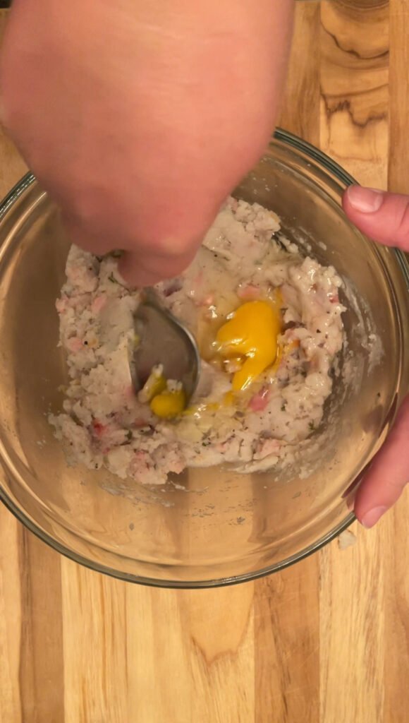 adding raw eggs is the final step in making this tortellini filling