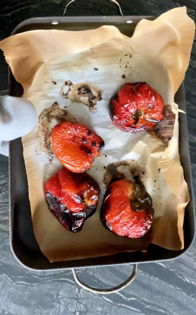 fully roasted peppers partially collapsed with their peel looking charred 