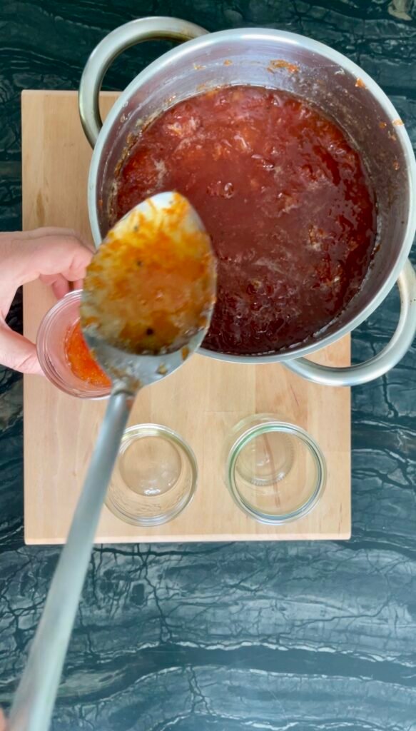 we show off translucent- pink color of our grapefruit jam before pouring it into the canning jars