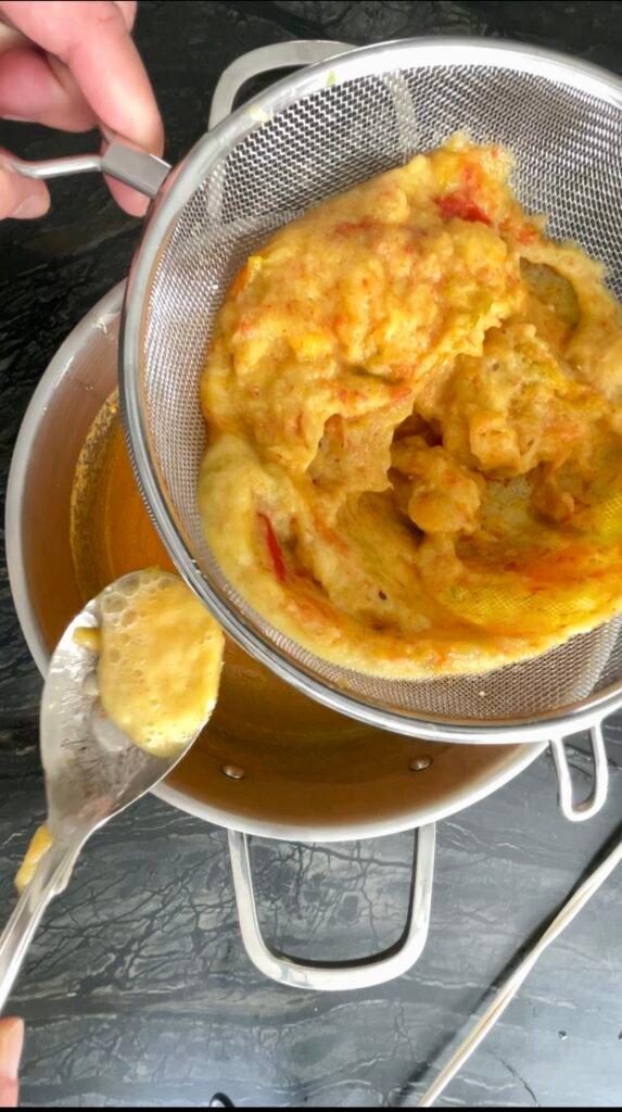 hot pepper jam prep - scrape pulp pushed through a meal strainer straight into the pot