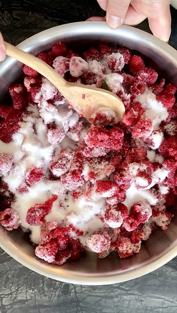 Raspberries and sugar mashed together in the pot