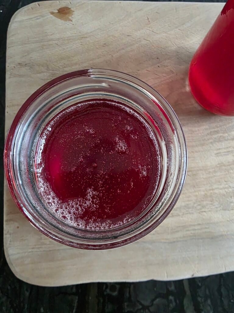 cooked huckleberry jelly in a glass jar, clear and glossy