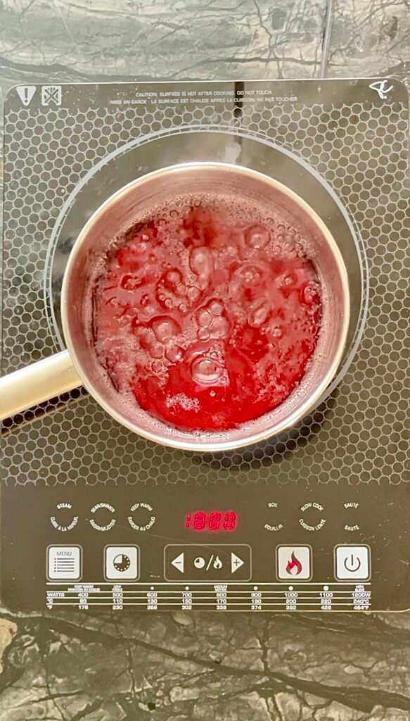 huckleberry jelly cooking in a pot