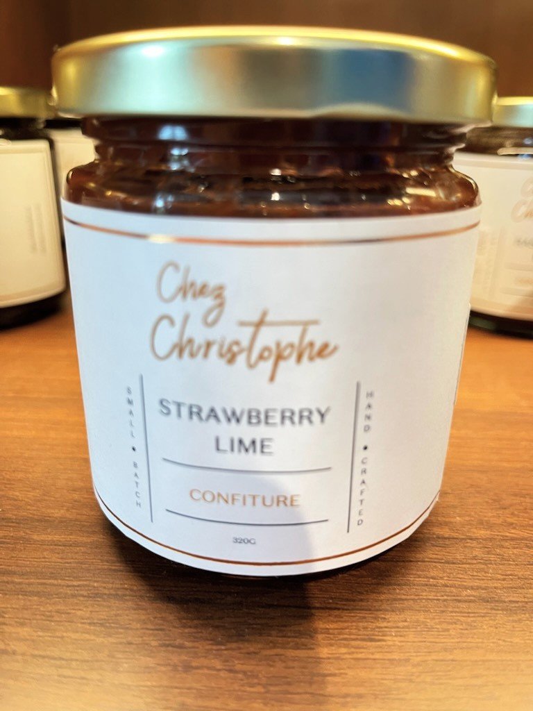 jar of Chez Christophe strawberry lime jam sitting on a wooden counter