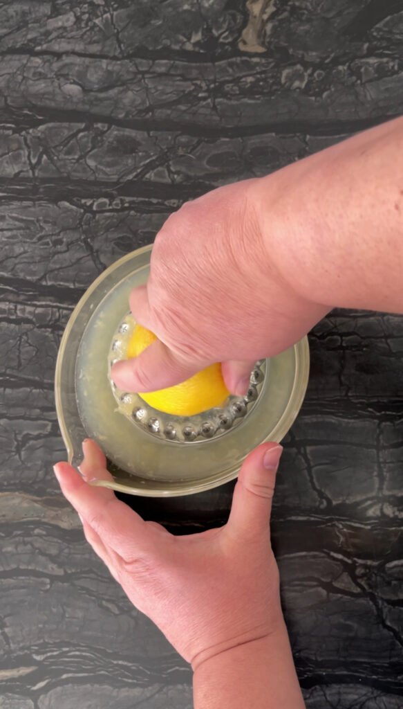 Squeezing lemon juice into a reamer 