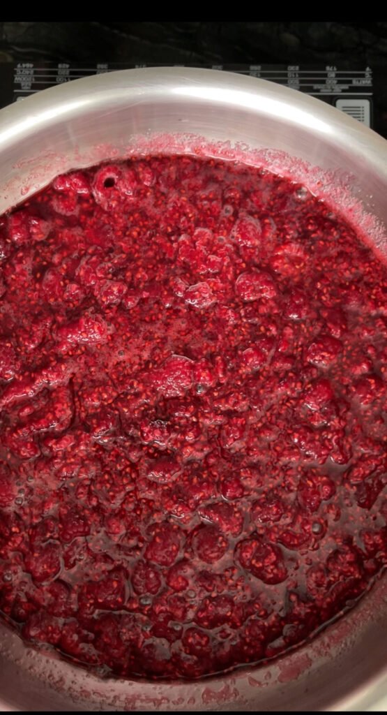 raspberries and their juices in a metal pot