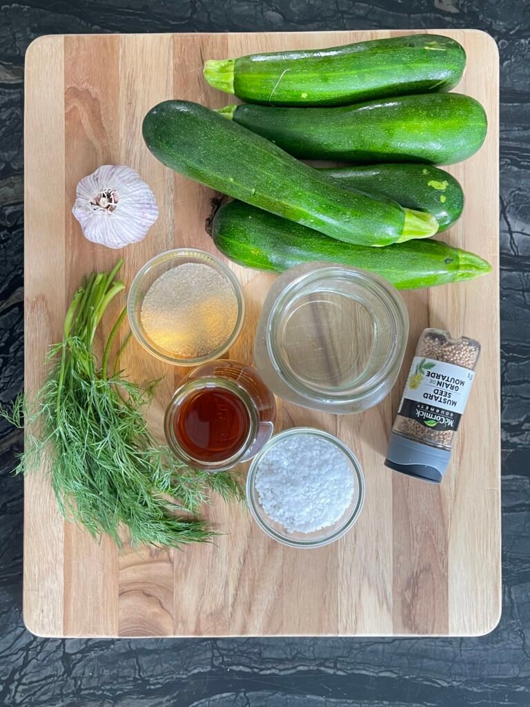 Ingredients for zucchini pickles recipe for canning - zucchini, garlic, dill, water, vinegar, salt, sugar, and mustard seed