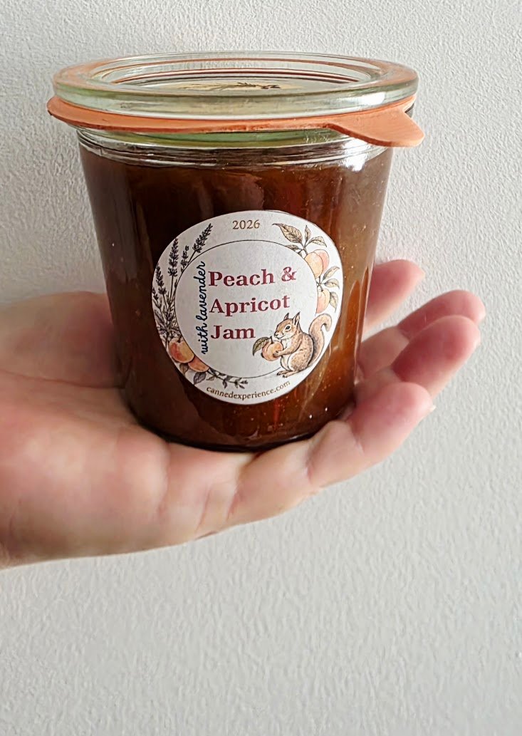 finished jar of peach apricot jam showcasing its custom label is held in a hand