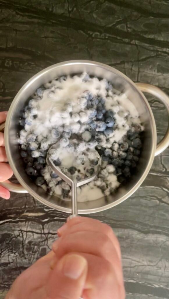 Making Blueberry Orange Jam — mashing blueberries with a potato masher
