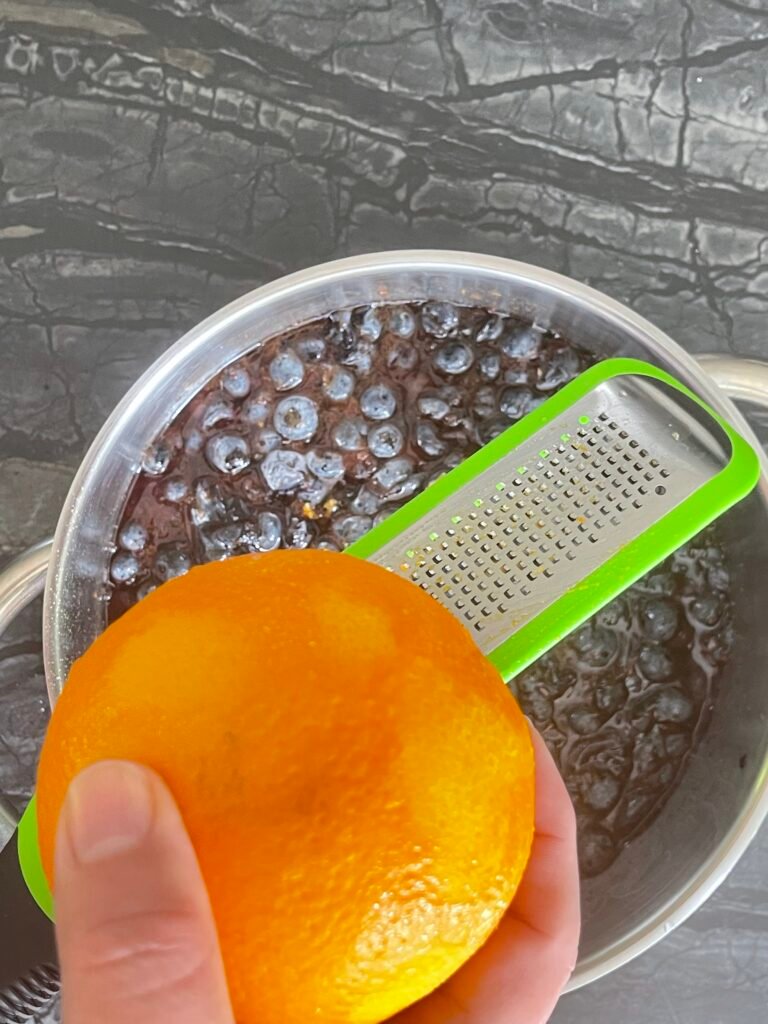 Making Blueberry Orange Jam — zesting orange into the jam