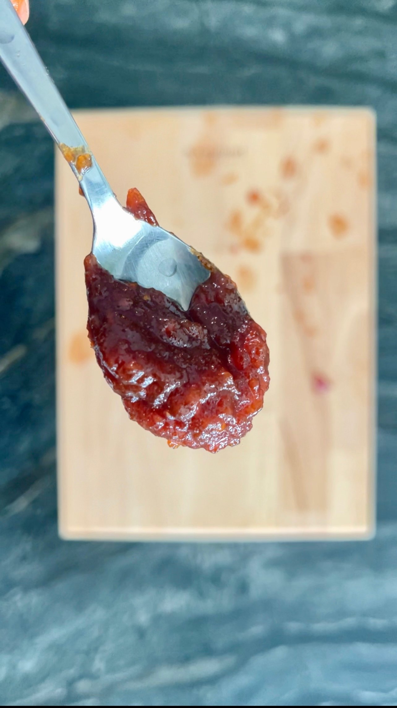 spoonful of tomato jam showing its glossy, set texture